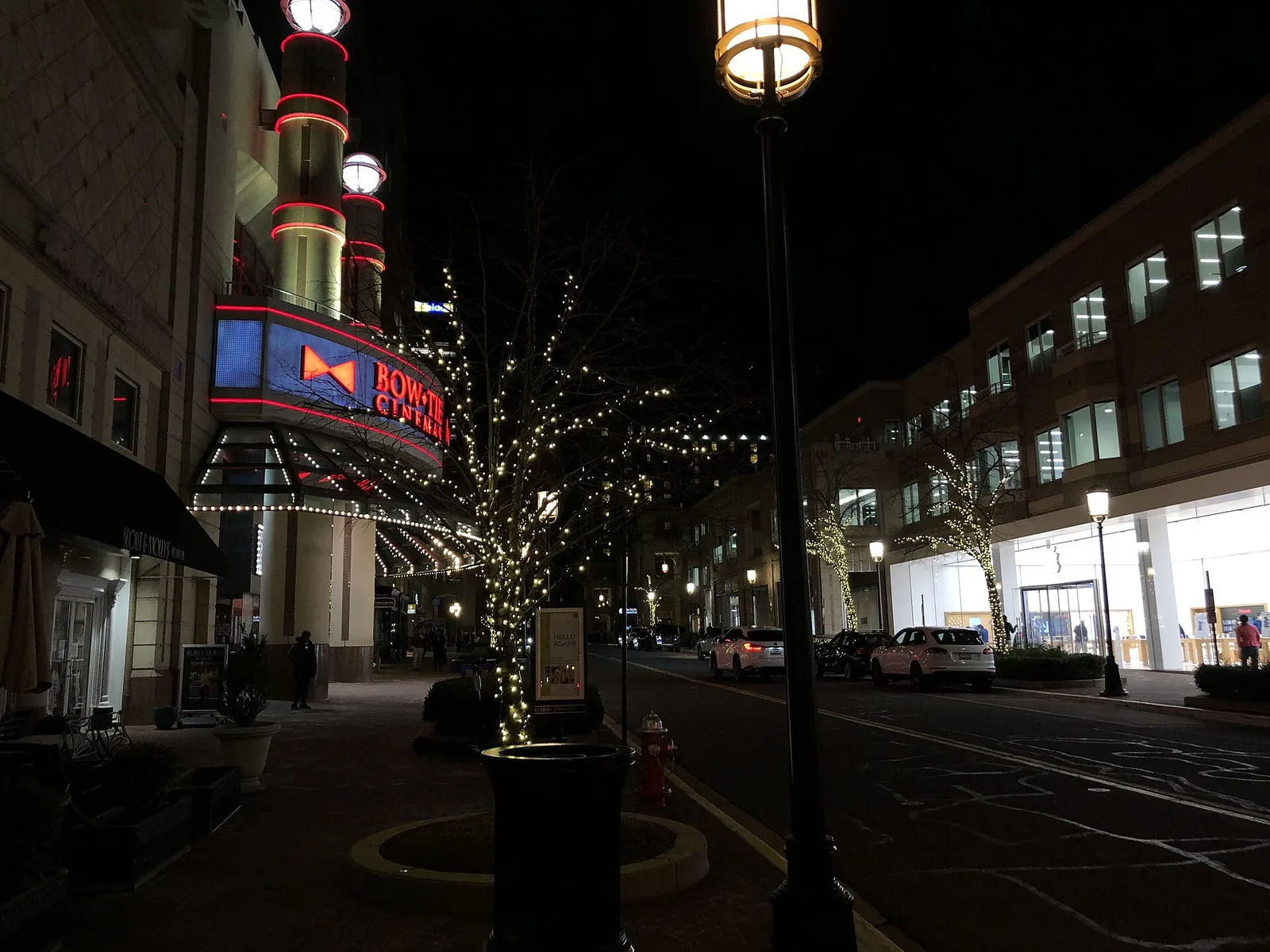 Market Street at night in Reston Town Center, with the cinema marquee and trees wrapped in lights